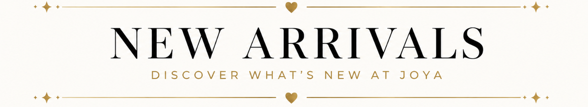 A promotional banner with the text 'NEW ARRIVALS' in large black serif letters, with smaller gold text reading 'DISCOVER WHAT'S NEW AT JOYA' below, on a warm off-white background with decorative gold lines and hearts.